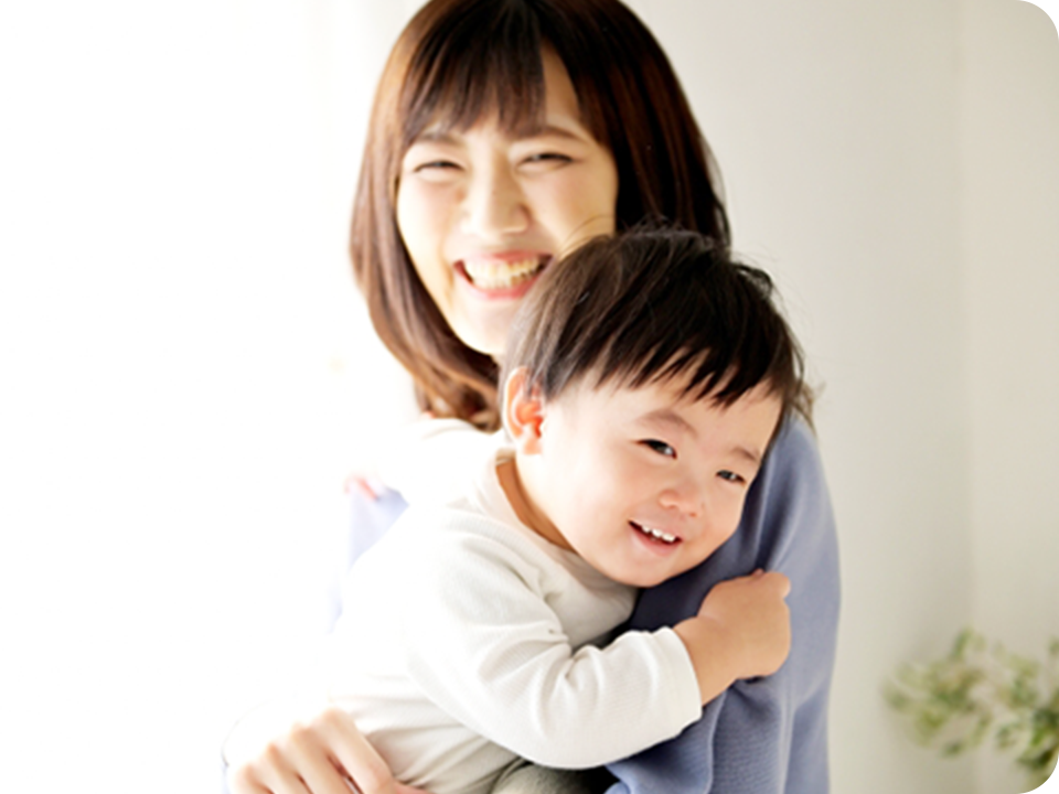 ママが赤ちゃんを抱えて笑う写真